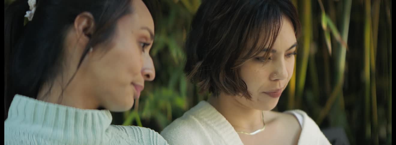 Two women sit outside and talk and then hug one another