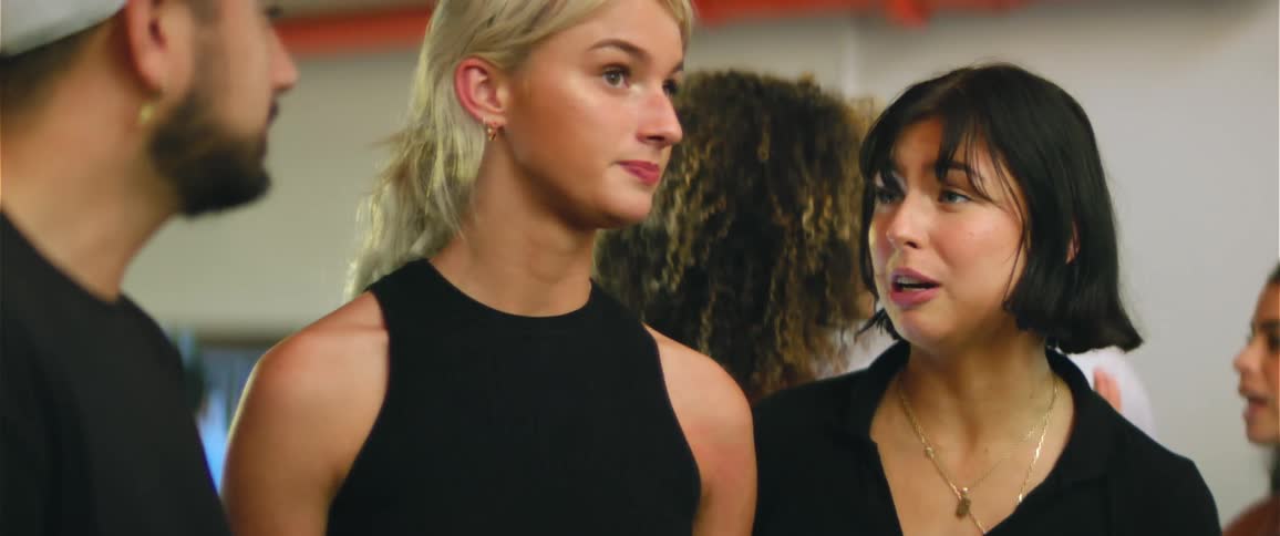 Group of friends wearing black clothes talk while standing on a gallery