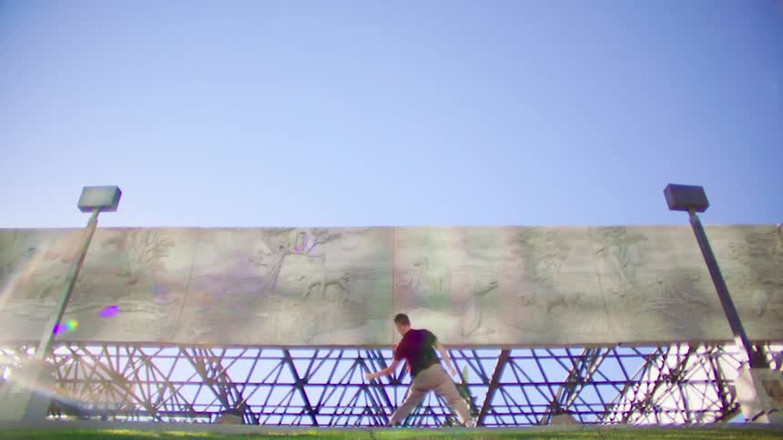 A man dances around by the billboard