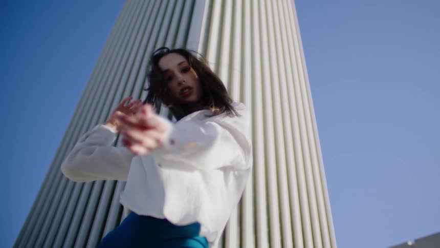 A woman is dancing near the tower