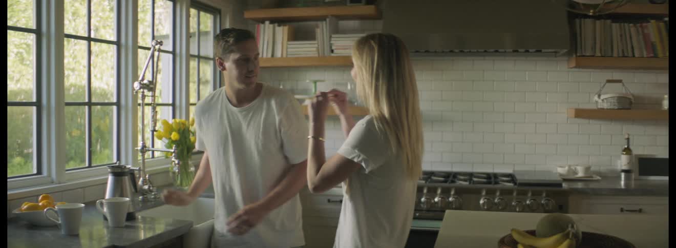 Woman surprises her partner with a pregnancy test in the kitchen at home in the morning