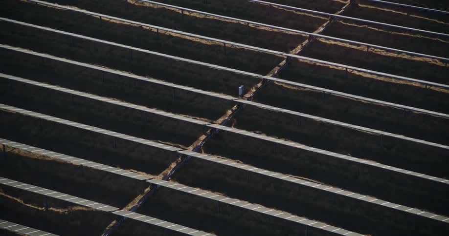 The sun shines on solar panels on a solar farm
