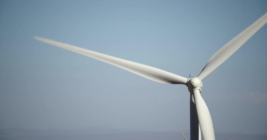 A wind turbine is spinning in a clear sky