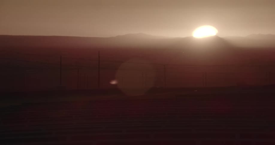 Big sun rises over the mountains in the desert at morning