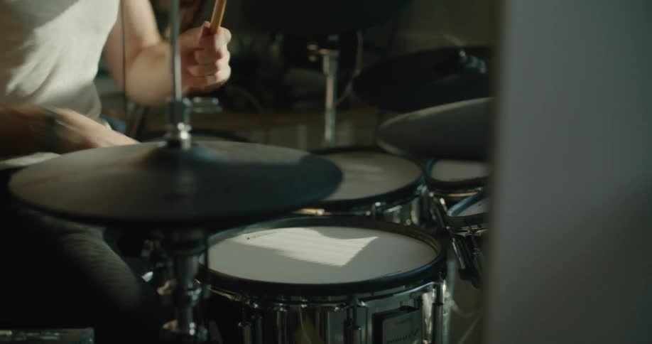 A man is playing the drums at home