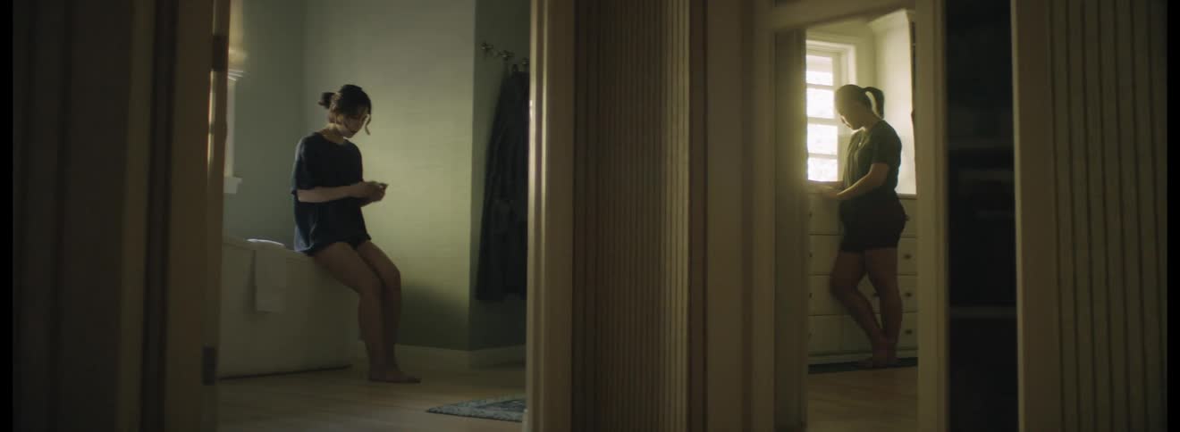 Two women standing around in a house