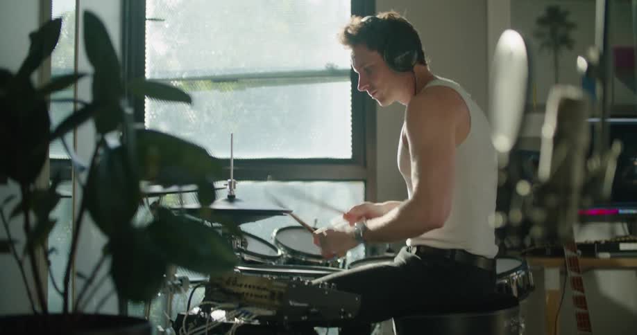 A man is playing drums at home