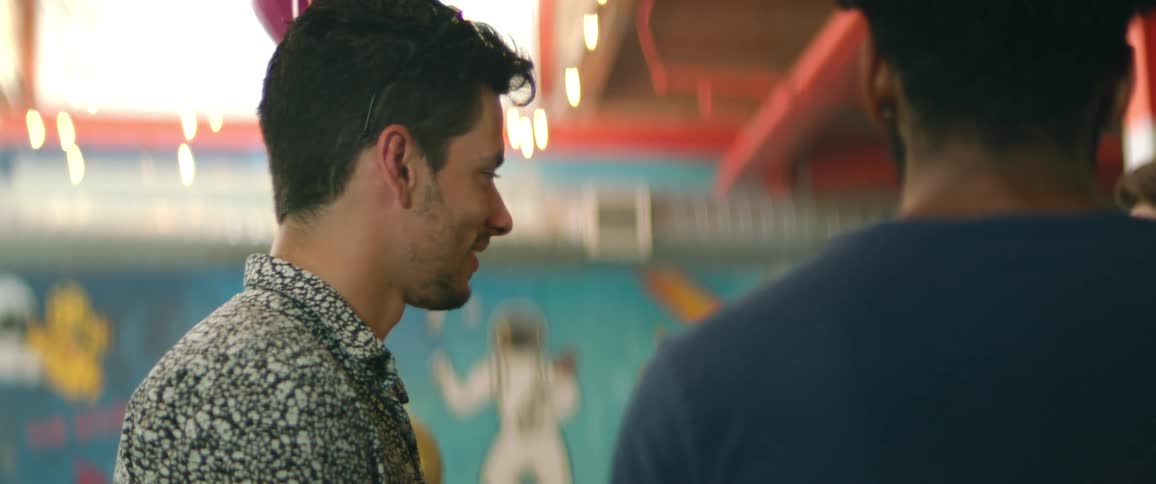 Three men stand in a building together and talk