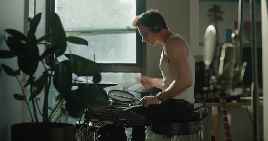 A man plays the drums at home