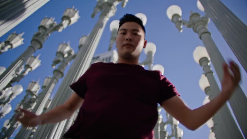 A man is dancing under the rows of lamp posts