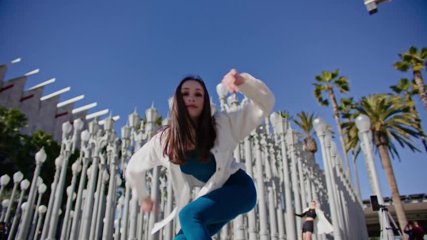 A woman is twisting and dancing outside