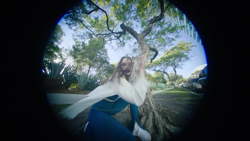 A woman is dancing in front of a tree