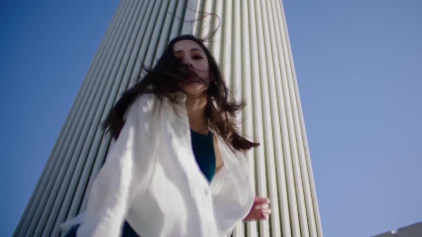A woman is dancing on a sunny day
