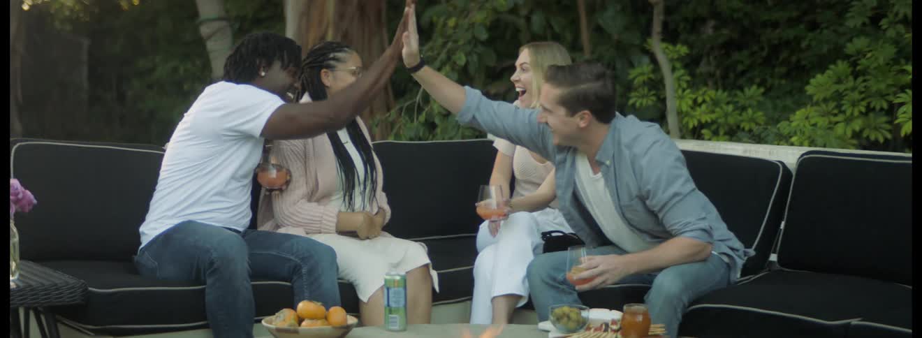 The men high five and the women hug when one announces she is pregnant