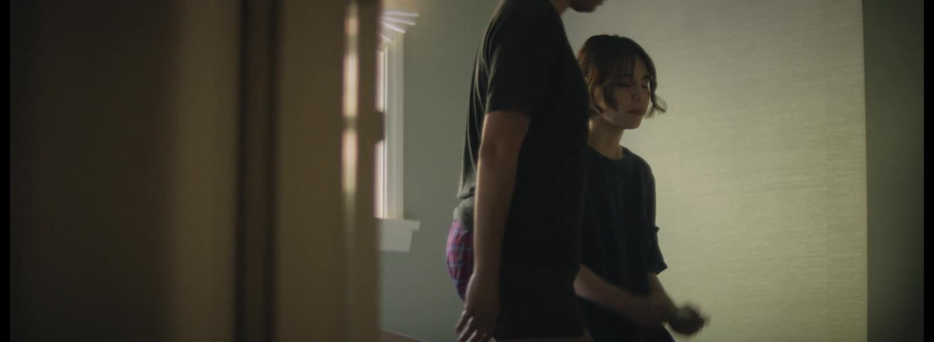 A woman hugs her friend holding a pregnancy test in the bathroom
