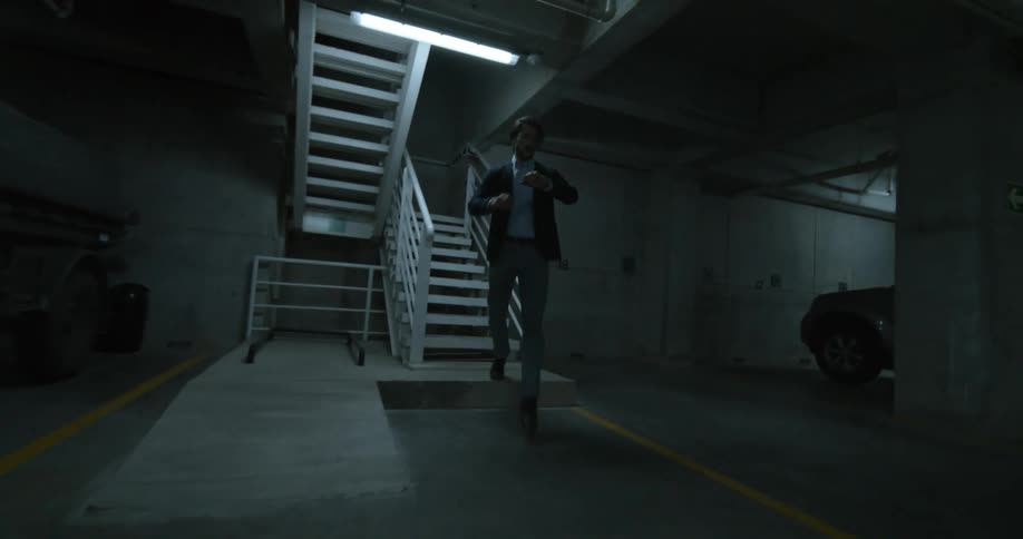A man rushes down the stairs into the parking garage
