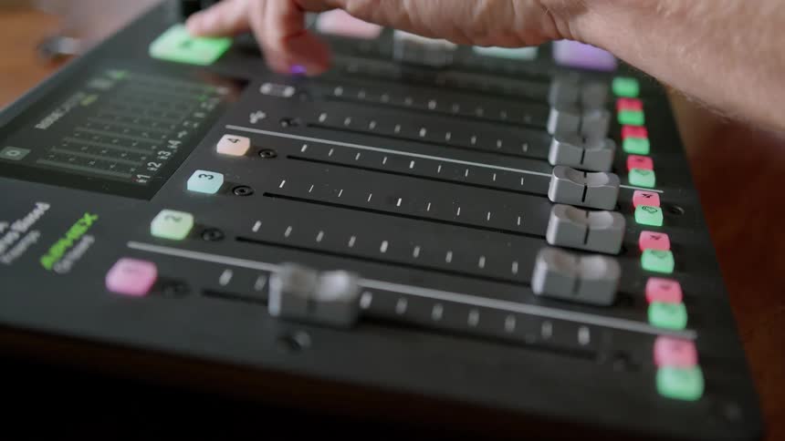 Caucasian hand pushes up a slider on an audio control device then presses a record button