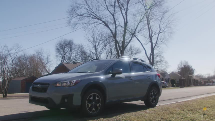 Car parking on the curb of a road in a neighborhood turns on emergency lights