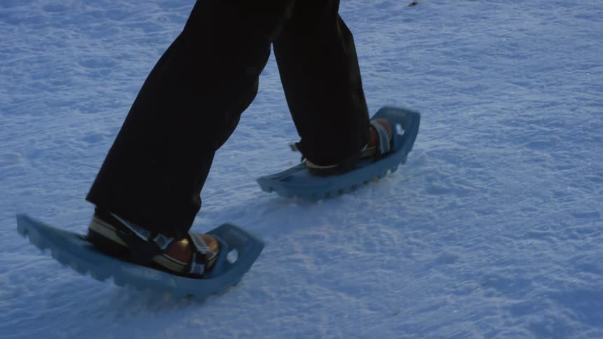 A woman is hiking over the frozen lake