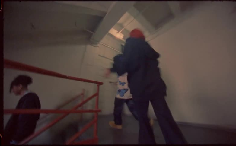 A time lapse of three teenagers running down a corridor and down stairs
