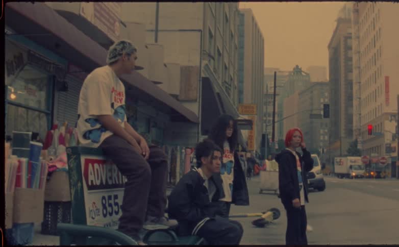 A group of teenagers hang out in the street