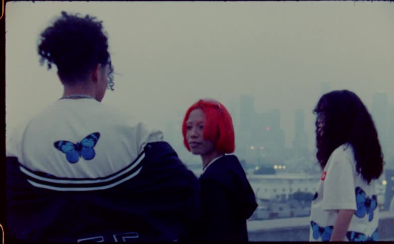 Three people stand on the roof top on a foggy day