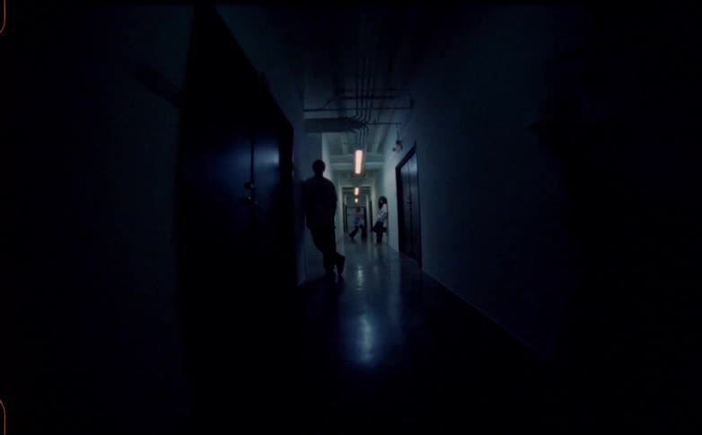 One teenage dances in a hallway as others lean against the walls while the lights turn on and off