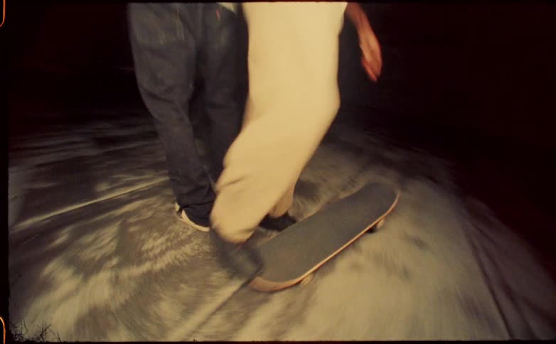 Two people pick up their skateboards