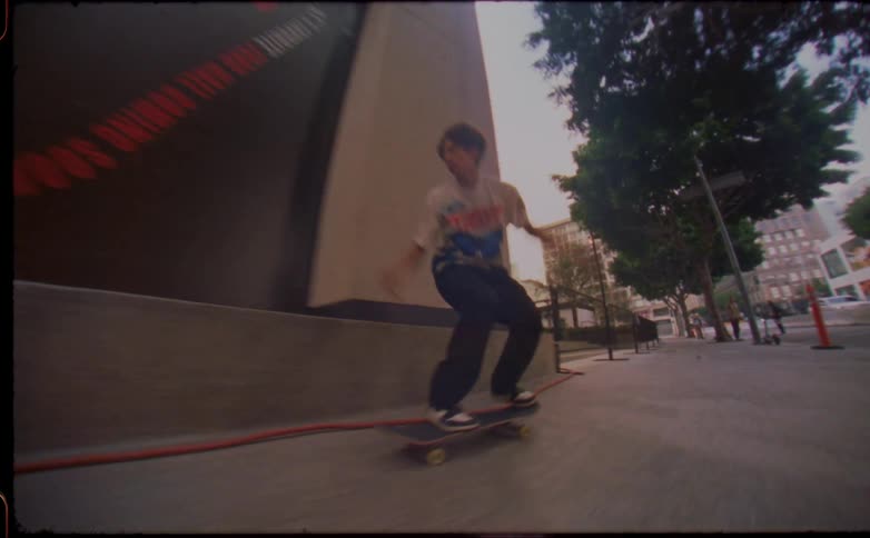 Teenager falls from a skateboard after trying to slide over a concrete wall in the city
