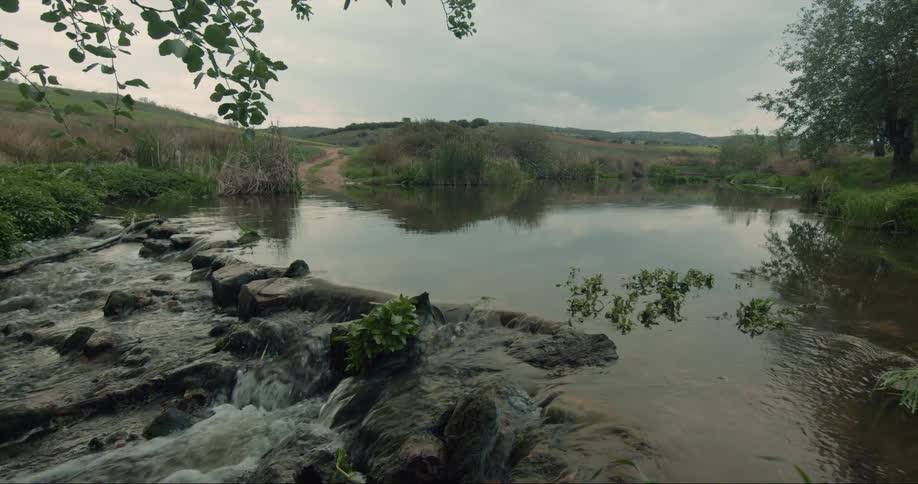 Water runs down over rocks in a country creek on a cloudy day