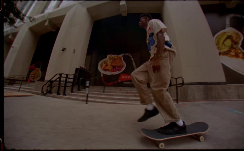 Young man riding a skateboard doing tricks on the city street caught on vintage film
