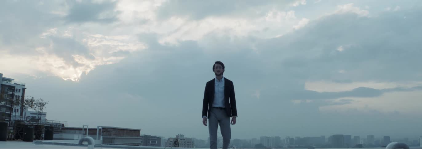 A man walks across the rooftop of an apartment building
