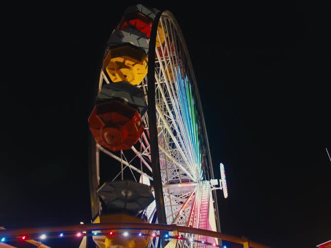 Ferris wheel turns around pointing into the sky at amusement park