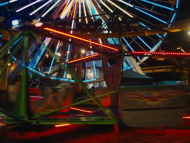 Amusement park rides are lit up and running at night