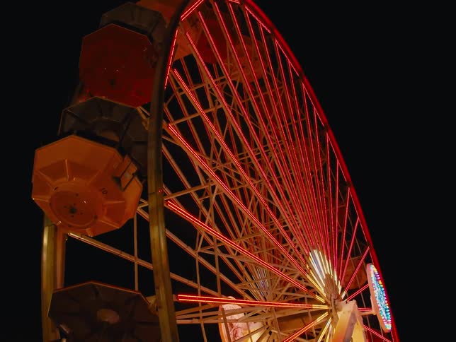 Ferris wheel turns around pointing into the sky at amusement park