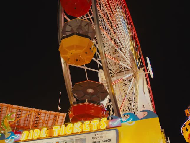 Ferris wheel turns around pointing into the sky at amusement park