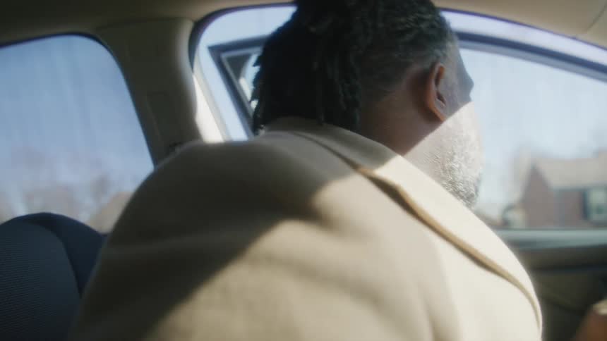 A man takes his seatbelt off and leaves the car