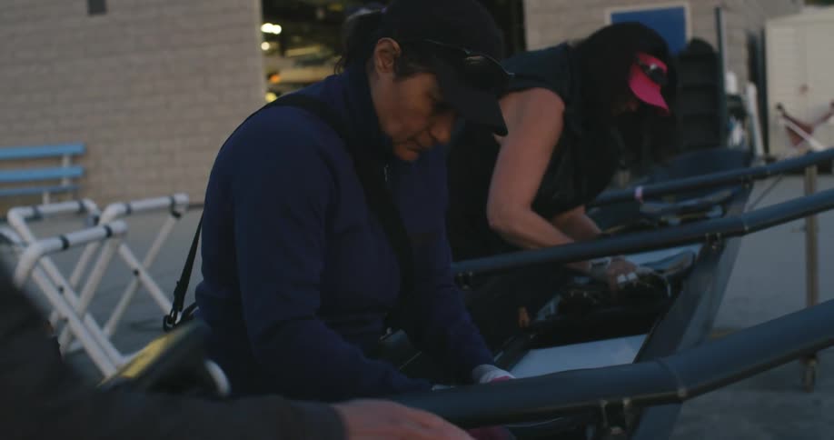 Group of women placing seats inside a row boat outdoors in the morning
