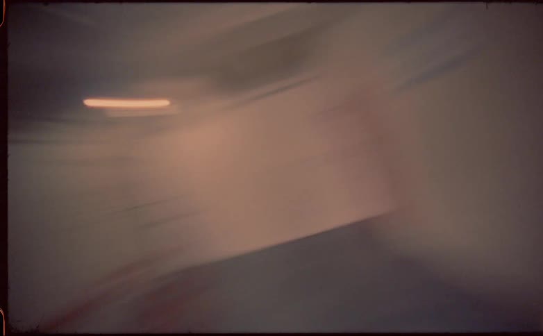 Windows and red rails pass by as blur while spinning in place