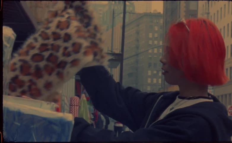Young woman with red hair shopping in the city street caught on vintage film