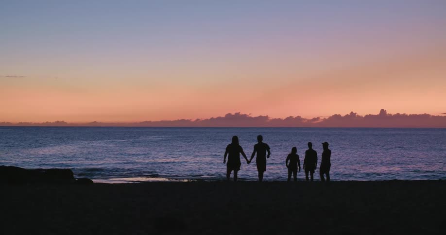 A group of people stand on the beach together