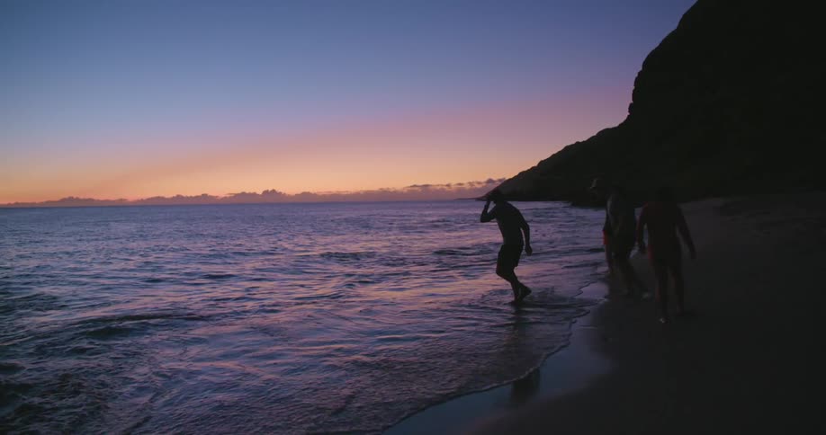 A group of people run in and out of the water