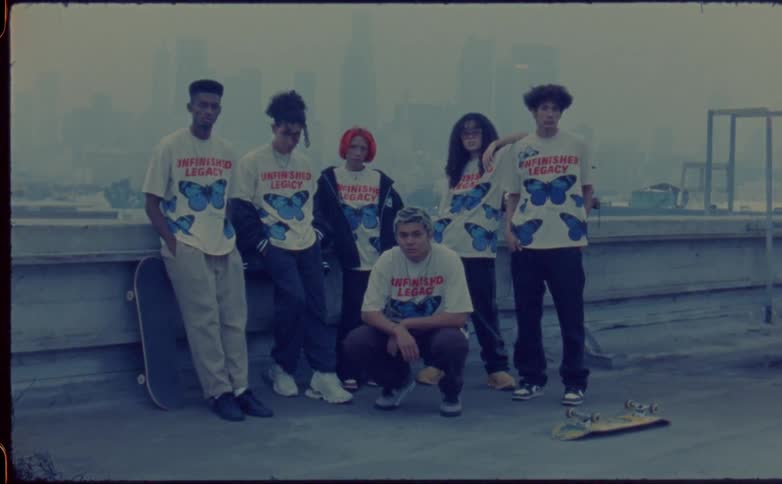 Group of friends modeling for the camera on the roof of a building close to the city skyline caught on vintage film