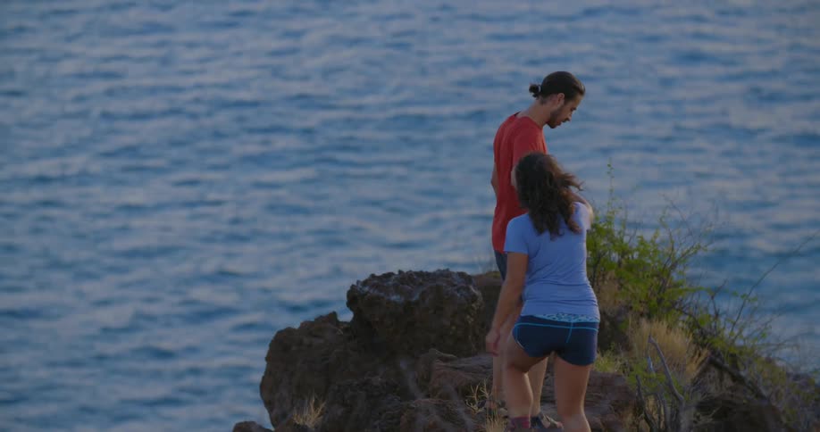 A man leads a woman on the rocks