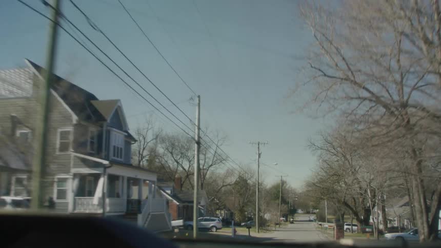 Car drives down the street with utility poles
