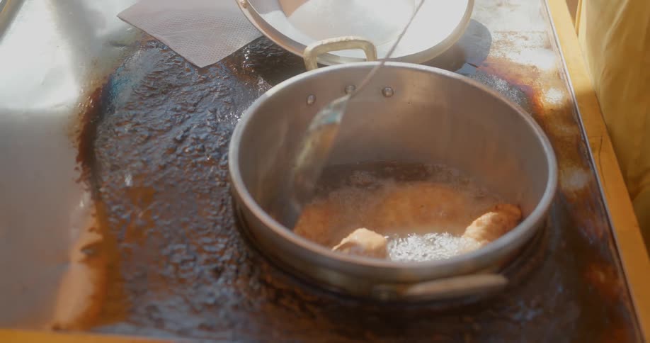 A person cooking in a large pot outdoors