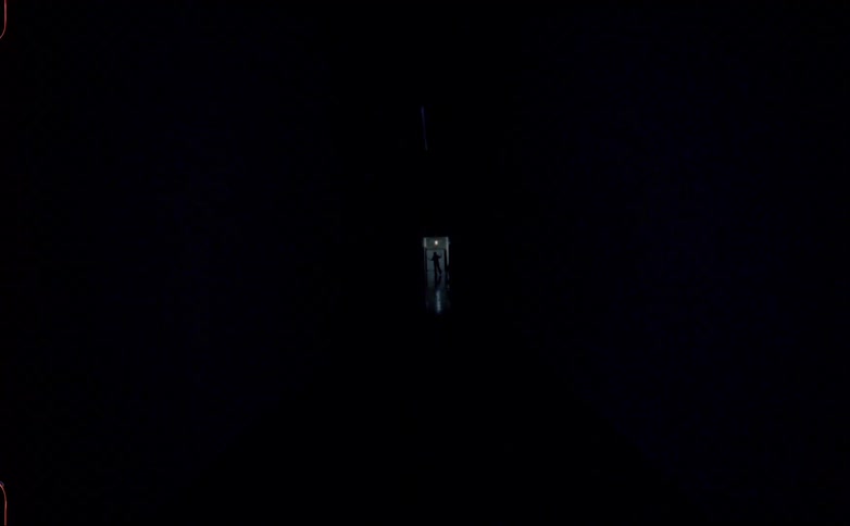 Teenagers standing on the doors of a dark hallway with lights turning on and off