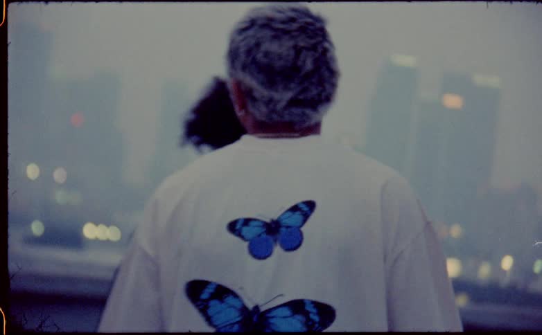 Two young friends walking on the roof of a building next to the city skyline covered in fog