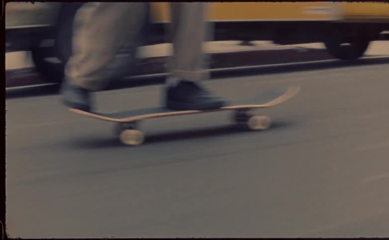 Speed up of a young man riding a skateboard on the city street caught on vintage film