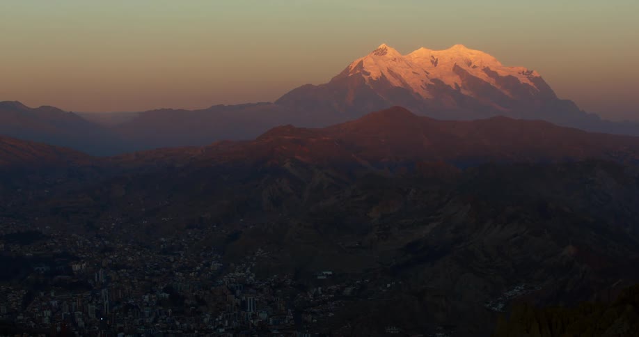 The snow on a mountain peak glows golden